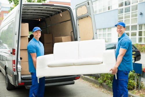 Furniture removal team carefully moving a sofa through a home interior