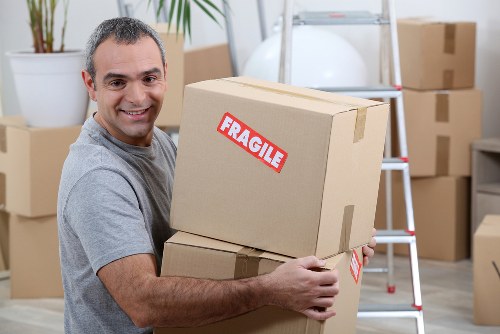 Professional movers wrapping a sofa for safe furniture removal