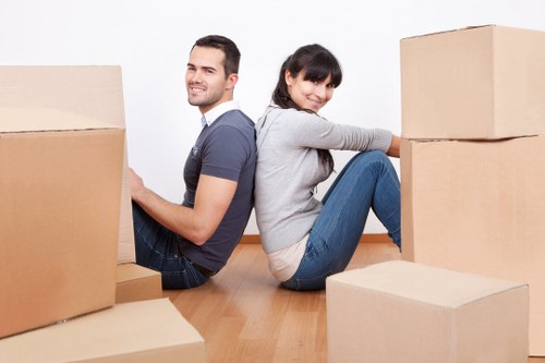 Moving team handling large furniture with protective wrapping and care