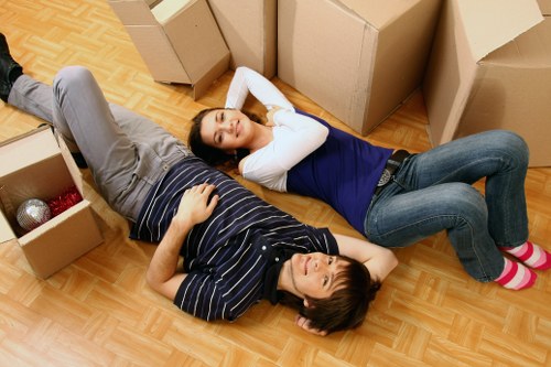 Movers securing fragile furniture with straps and blankets