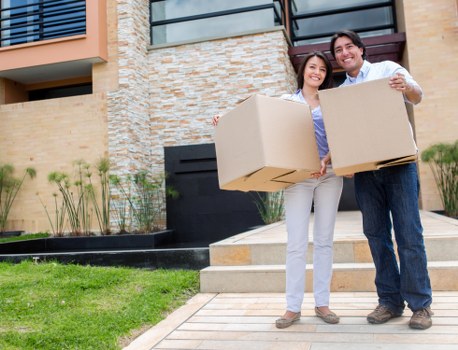 Removal team carrying a wardrobe through a home hallway